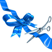 Blue ribbon cutting business concept with a three dimensional silk bow being cut by metal scissors as a symbol of launching and unveiling an important announcement or celebrating success.